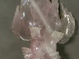 a close up of a piece of pink quartz on a white surface