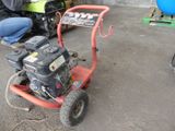 a man sitting on the ground working on a small lawn mower