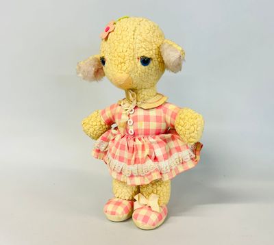 a small stuffed animal wearing a pink dress and shoes