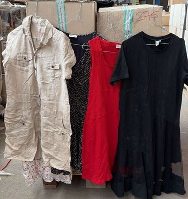 de nombreux types de vêtements différents suspendus à un portant dans un entrepôt