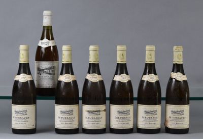 several bottles of wine are lined up on a glass shelf