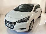 La voiture blanche est garée dans le showroom d'un concessionnaire.