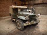 a military truck parked in a garage with a tent on top of it