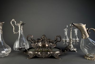 cinq vases en verre et un plat en argent posés sur une table