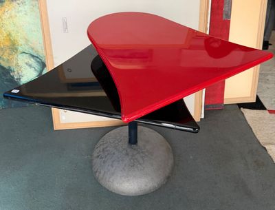 une table rouge avec un plateau noir et un piètement noir