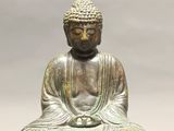 bronze statue of a seated buddha on a lotus - shaped base