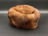 un bonnet en fourrure marron posé sur une surface noire