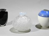 trois vases posés l'un à côté de l'autre sur une surface blanche