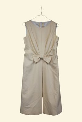 the back of a white dress with a large bow on a hanger