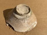 a clay vase that is sitting on the ground