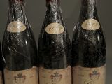 six bottles of wine are lined up on a table