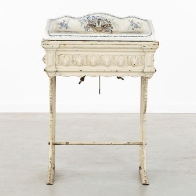 un évier blanc à l'ancienne, orné d'un motif floral sur le dessus