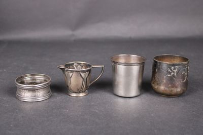 trois coupes en argent et une coupe en argent posées sur une table