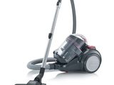 a close up of a vacuum cleaner with a hose on a white surface
