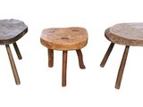 three wooden stools sitting next to each other on a white surface