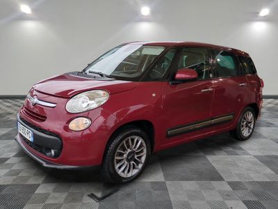 a red fiat car parked in a garage with a checkered floor