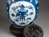 a blue and white vase with a lid on a stand