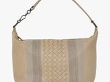 a beige leather bag with a braid design on the front