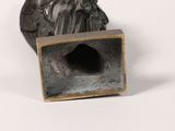 bronze statue of a man with a bird on his head in a box