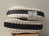 the soles of a pair of white and black running shoes on top of a cardboard box