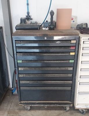une armoire à outils en métal comportant de nombreux tiroirs, dans un garage