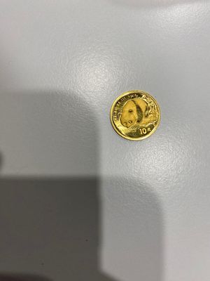 gros plan d'une pièce d'or sur une surface blanche