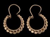 une paire de boucles d'oreilles en or sur fond noir