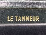 a close up of the name of a black leather bag