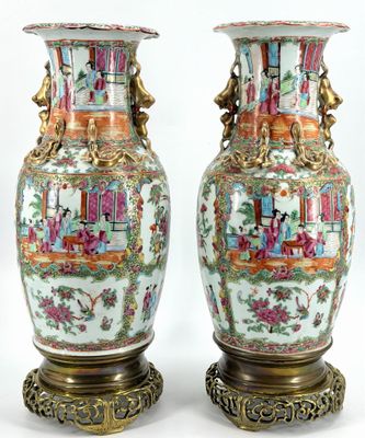 pair of oriental vases on stands with asian scenes on them