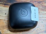 des AirPods noirs posés sur une table en bois