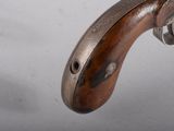 a close up of a gun with a wooden handle
