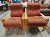 pair of orange upholstered chairs in a furniture store