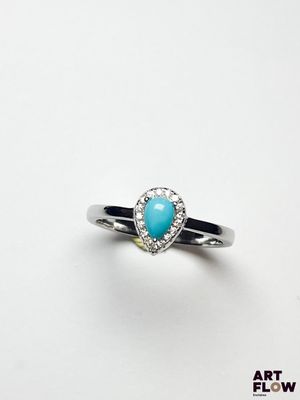 un gros plan d'une bague sertie d'une pierre de turquoise