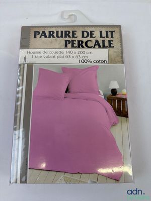 ensemble de literie violet dans son emballage, sur fond blanc, avec un sol en bois