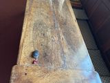 a wooden table with a bird on it in a room