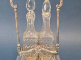 two crystal decanters sitting on a silver stand