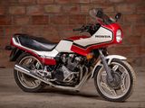 a red and white motorcycle parked in front of a brick wall