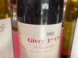 three bottles of wine sitting on a red table cloth