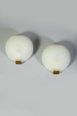 three white balls are sitting on top of each other on a white surface