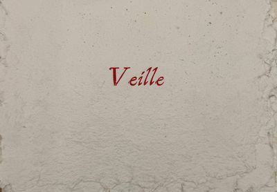 a red writing on a white wall that says veille