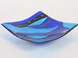 a blue glass bowl with a wave design on it