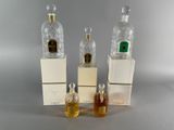 three bottles of perfume sitting next to each other on top of boxes