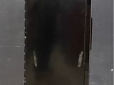 an image of a black refrigerator with a trash bag on top of it