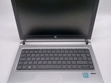 a silver laptop with a black keyboard on a white table