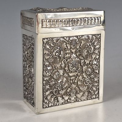 une boîte ancienne en argent ornée d'un motif floral sur le devant