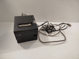 a small printer sitting on top of a table next to a charger