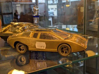 une maquette en or d'une voiture exposée dans une vitrine