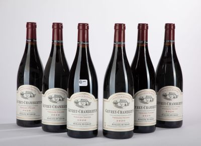 six bouteilles de vin sont alignées sur une table