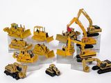tout un tas de petits engins de chantier en jouets posés sur une table