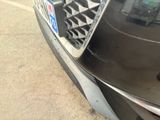 a close up of a car ' s grille with a cell phone attached to it